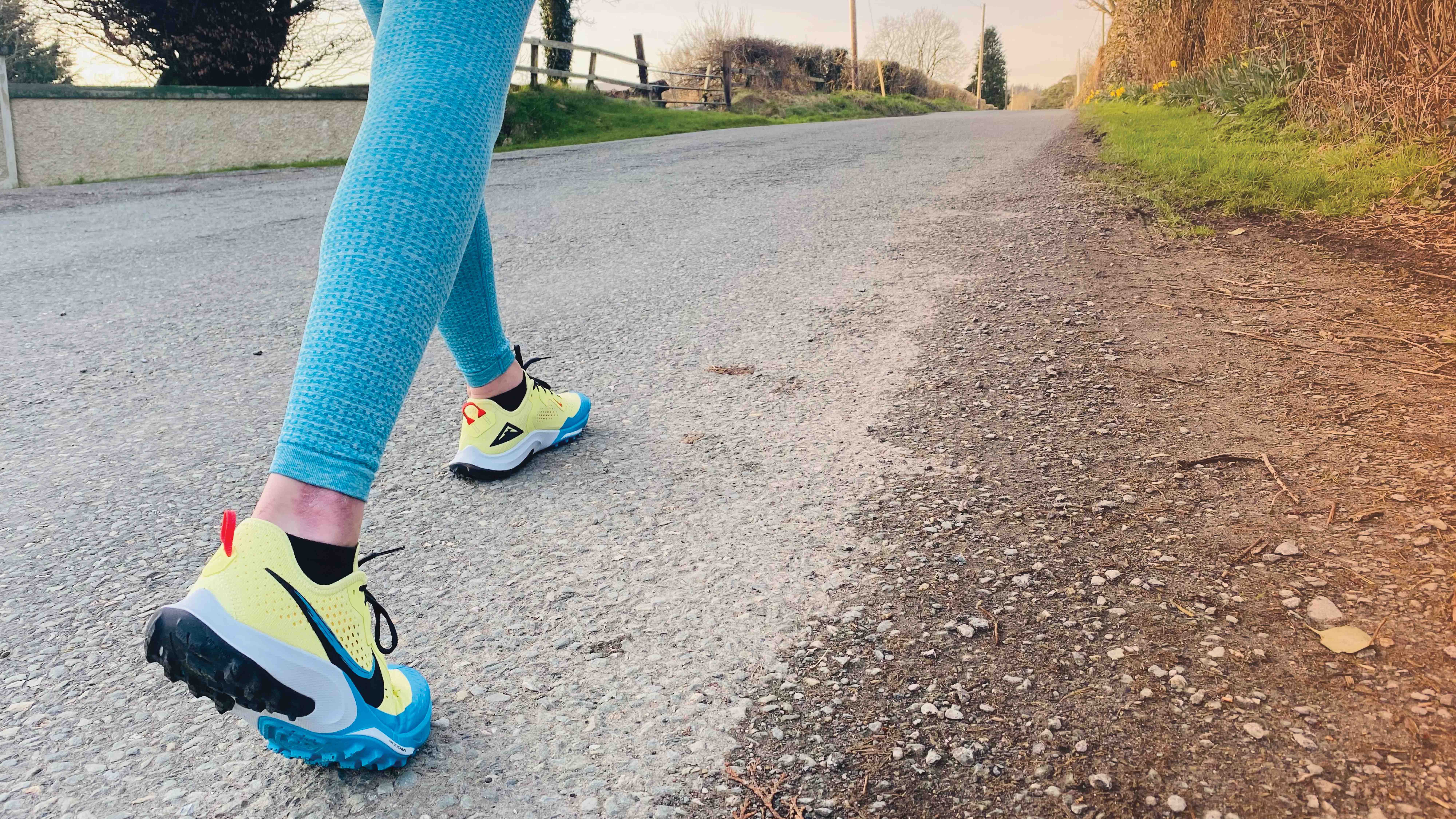 Image of woman in blue leggings walking on country road